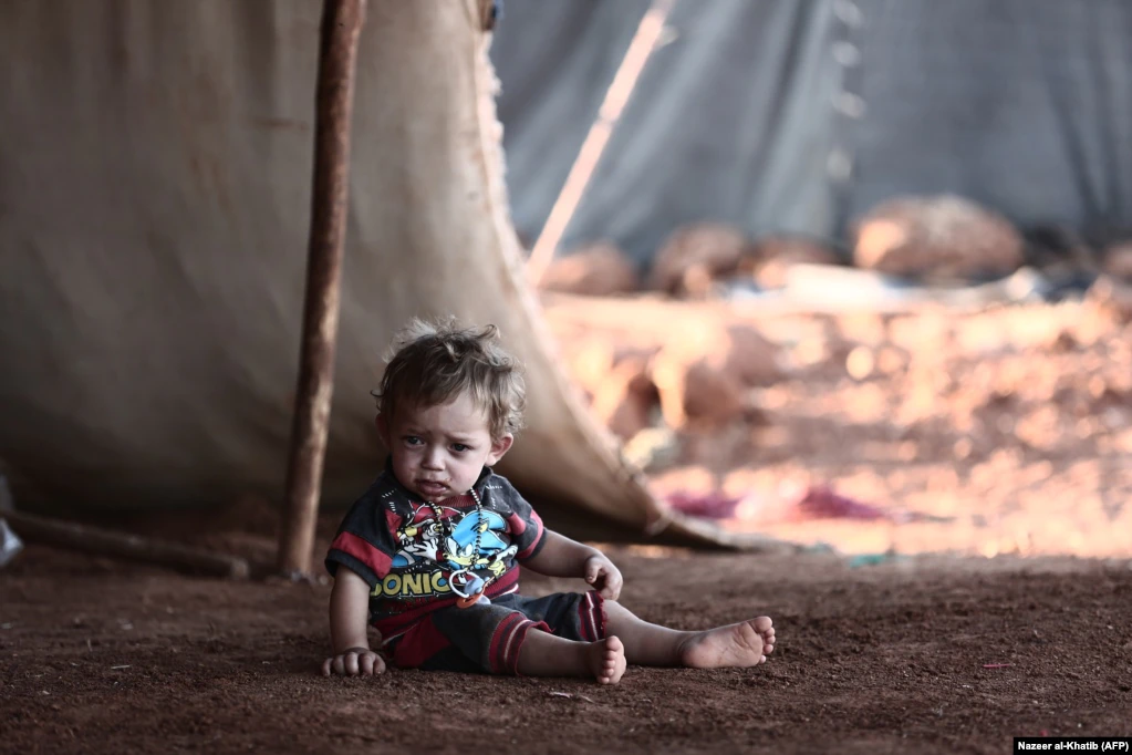 A child sits in front of a tent at a camp for the displaced from the rebel-held Syrian province of Idlib, in the village of Al-Ghadfa, southeast of the province. The Syrian regime and its ally Russia are threatening an offensive to retake the northwestern province, Syria&#39;s last rebel bastion. (AFP/Nazeer Al-Khatib)