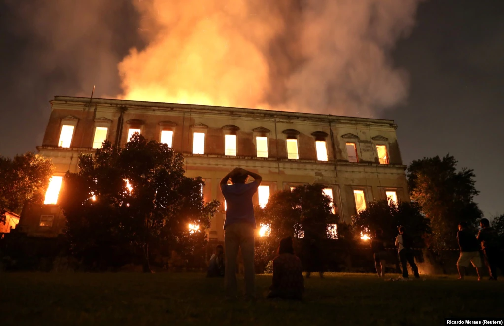 People watch as a fire burns at the National Museum of Brazil in Rio de Janeiro. Authorities fear the destruction of more than 20 million items. The cause of the fire is not yet known.(Reuters/Ricardo Moraes)