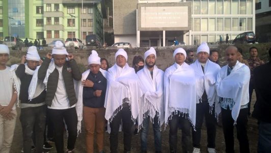 Laten Sherpa and Alembic Workers Cladded in white cloth, shaved head performing homage 